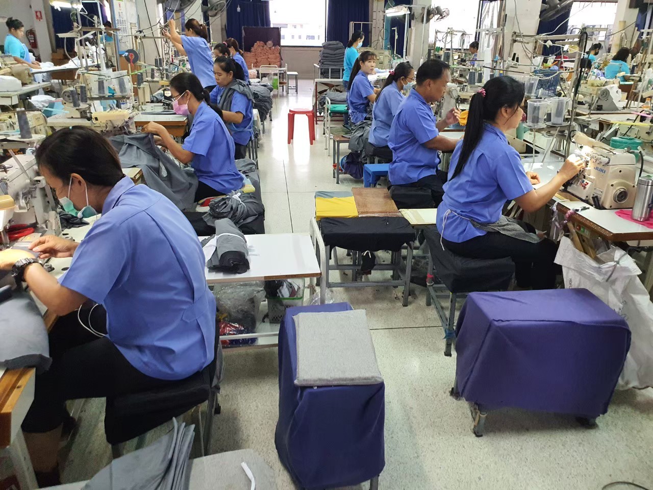 ทีมงานกำลังตัดเย็บเสื้อภายในพื้นที่ผลิตของบริษัท ลมหายใจ จำกัด